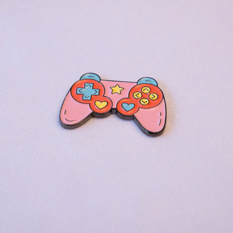 A pink game controller sticker with a mint d-pad, yellow and blue heart thumb sticks, and a star, seen from above.