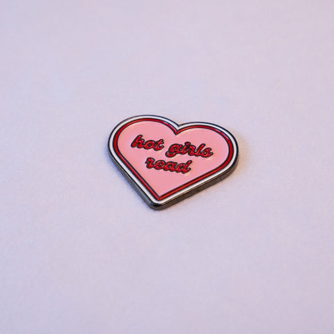 A pink heart with a silver rim, hot girls read lettered across it in red script.