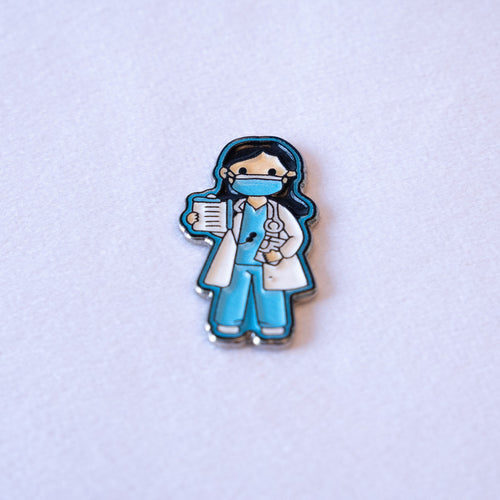 A cartoon doctor in a white coat over blue scrubs, blue mask on, stethoscope round her neck and a clipboard in hand.