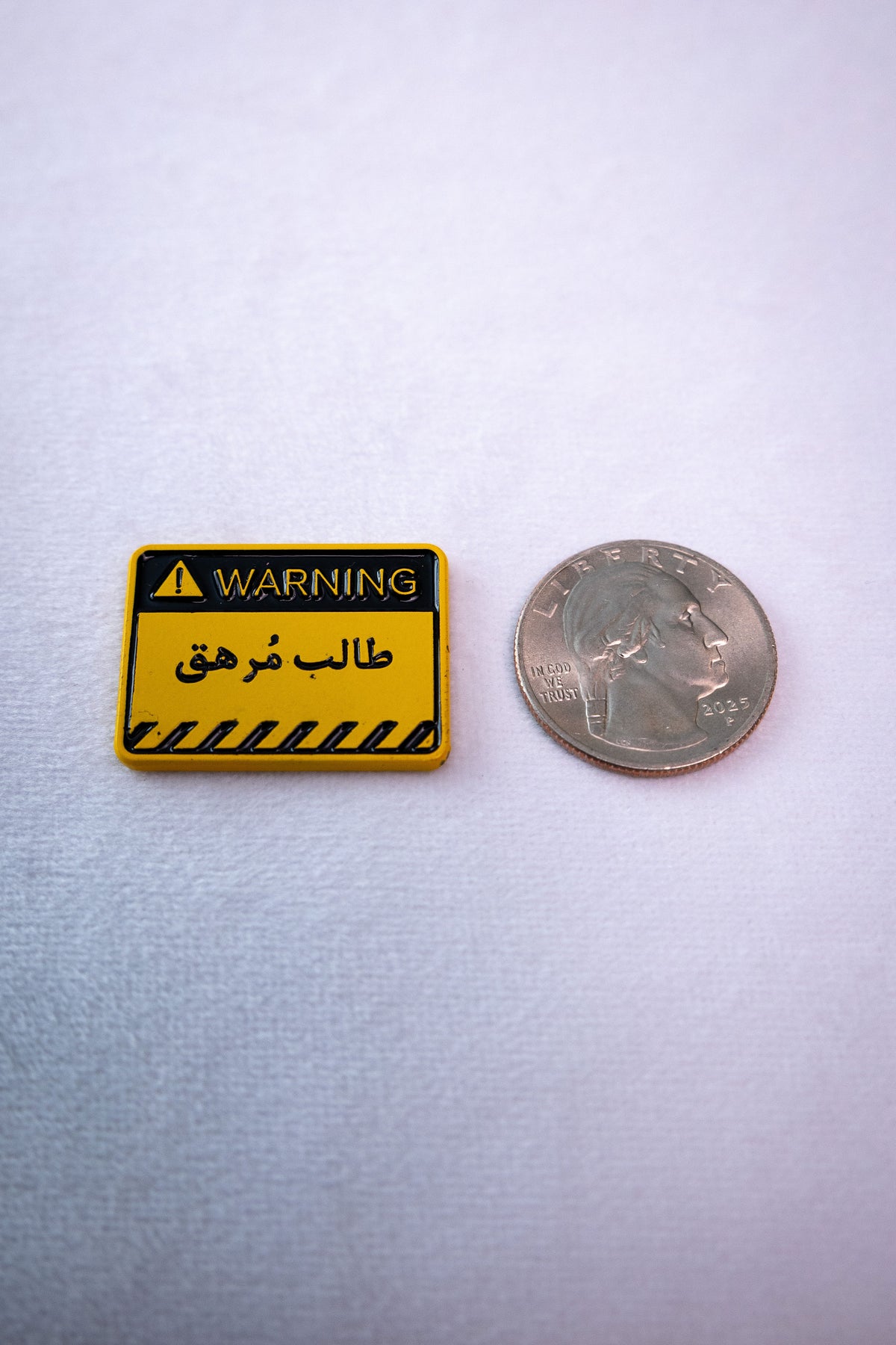 The Exhausted Student Warning Sign sticker beside a US quarter for scale.