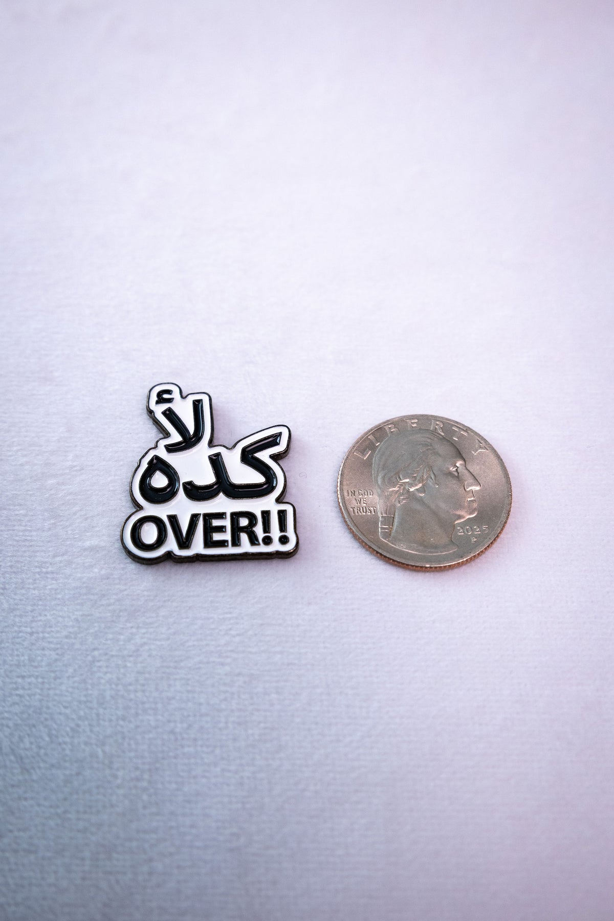 The Kida La' (كده لأ) Over sticker beside a US quarter for scale.