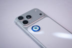 Blue-and-white evil eye (nazar) amulet sticker, applied to a phone case near the camera bump