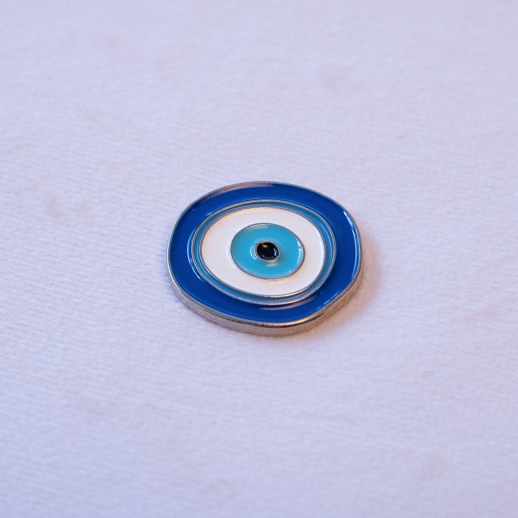 A blue and white evil eye, round, in metal.
