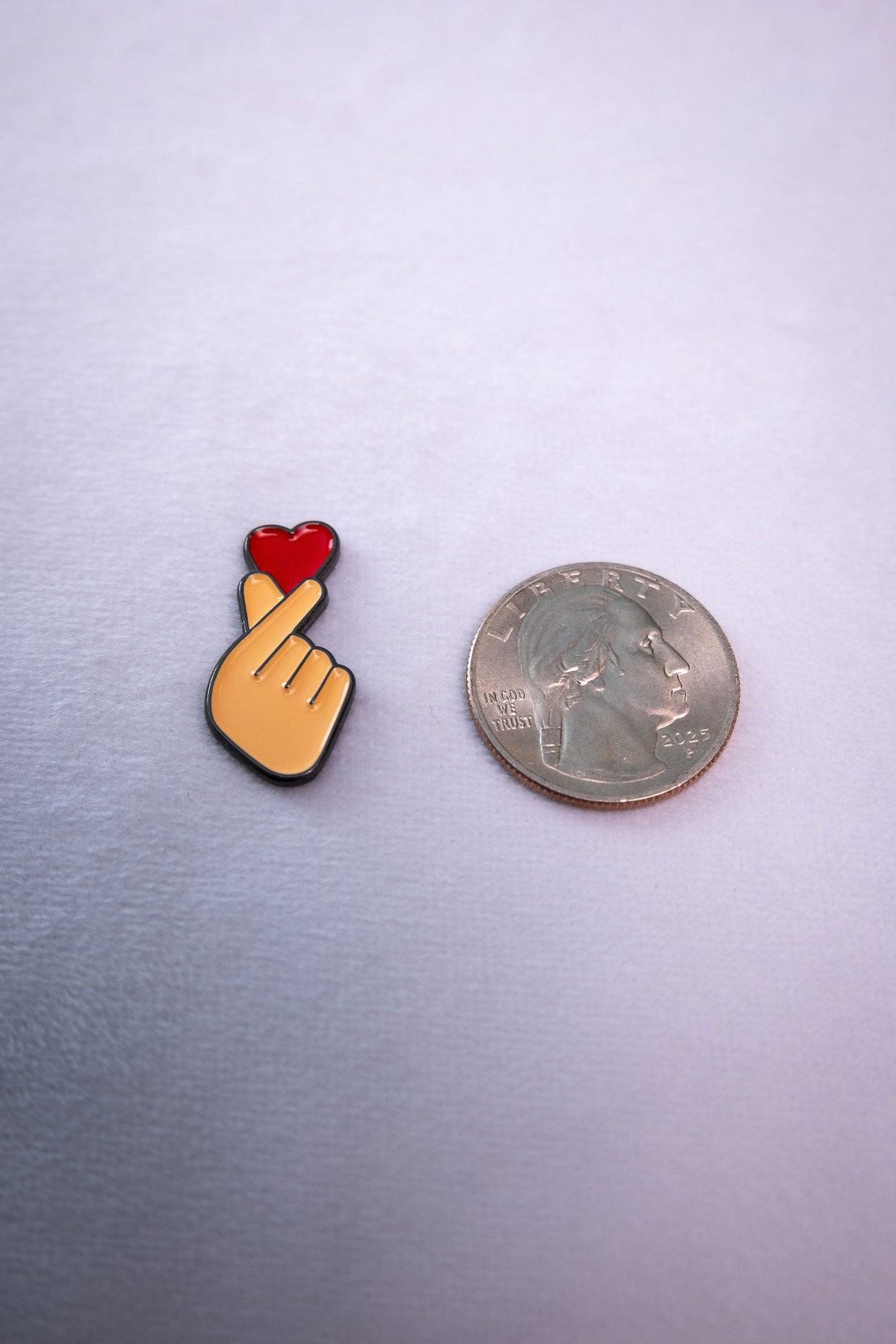 The Finger Heart sticker beside a US quarter for scale.