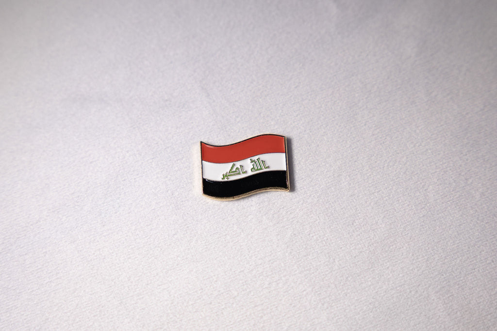 The Iraqi flag mid-wave with التكبير in green Kufic script across the white band.