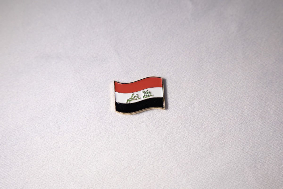 The Iraqi flag mid-wave with التكبير in green Kufic script across the white band.
