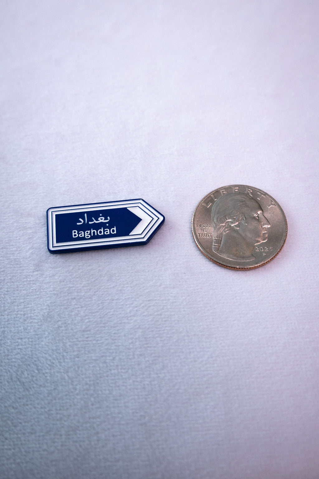 The Baghdad (بغداد) Road Sign sticker beside a US quarter for scale.