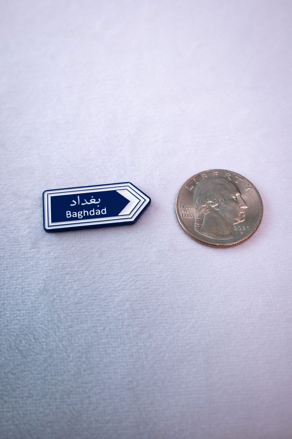 The Baghdad (بغداد) Road Sign sticker beside a US quarter for scale.