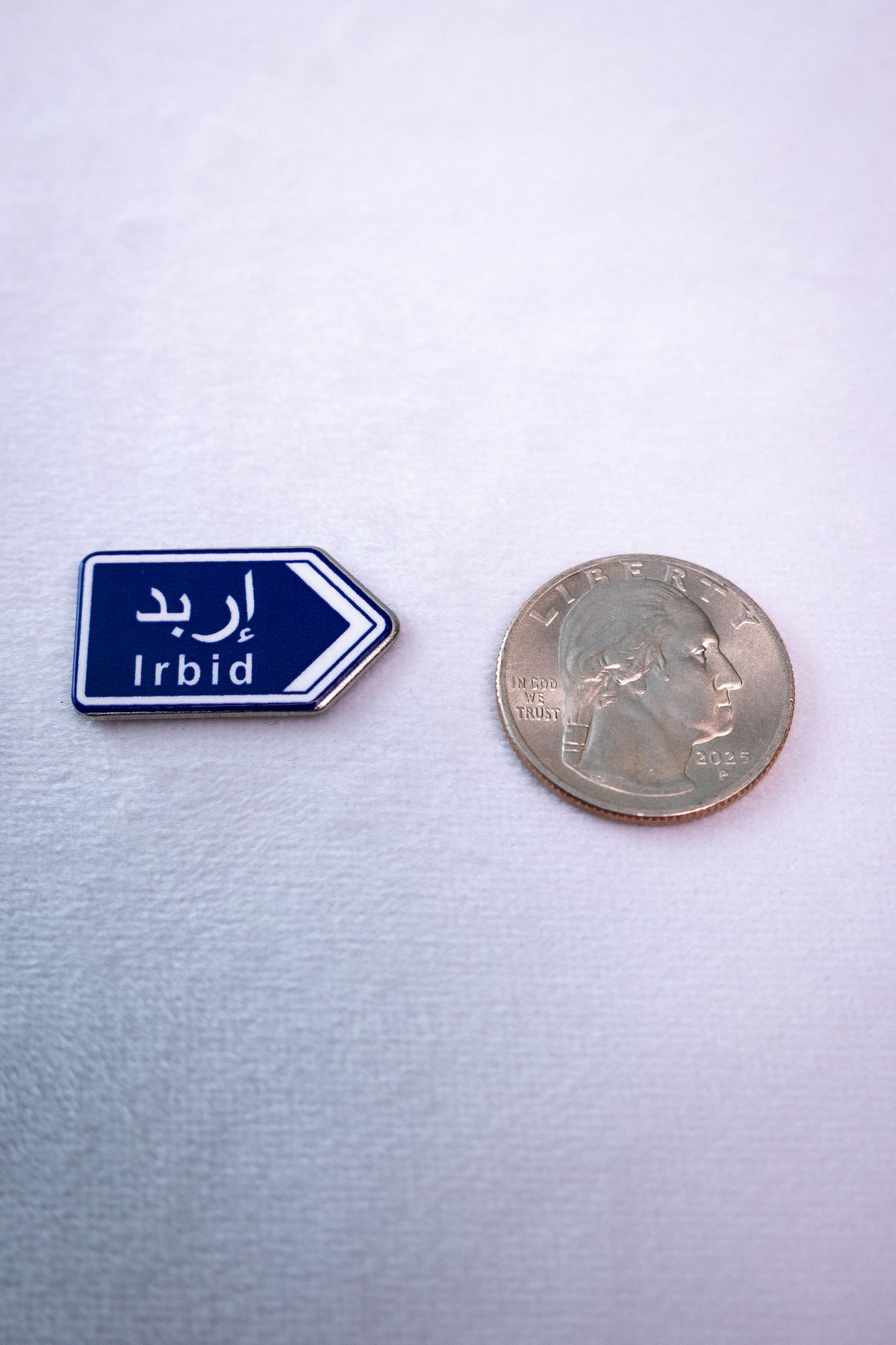 The Irbid (إربد) Road Sign sticker beside a US quarter for scale.