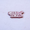 GIRL BOSS in burgundy serif capitals on two lines on a cream plate, with a pink bow trailing off the upper right, as a metal sticker.