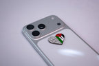 The Palestine keffiyeh heart metal sticker applied to a phone case near the camera bump.