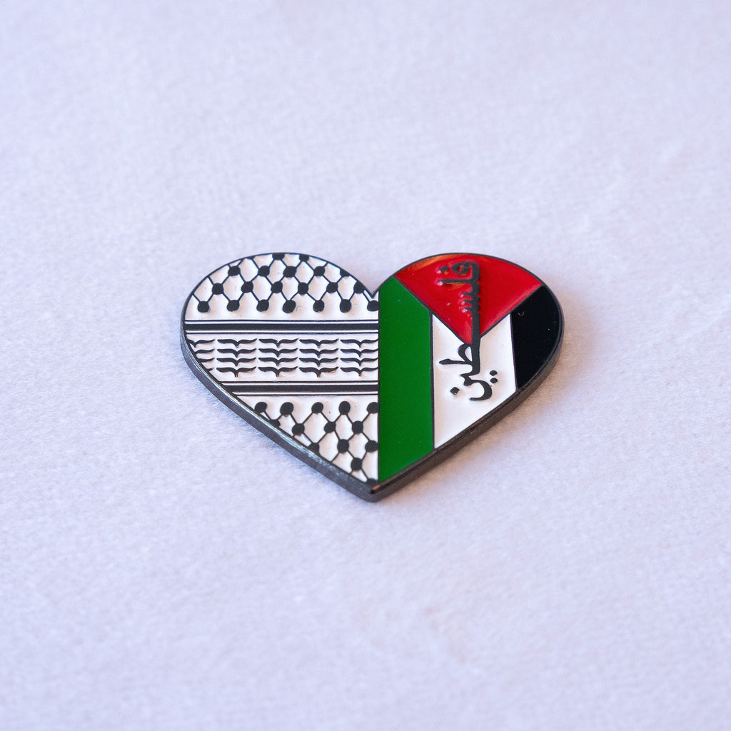 A heart split down the middle, keffiyeh weave in black and white on one side and the Palestinian flag on the other with فلسطين across the white band, as a metal sticker.
