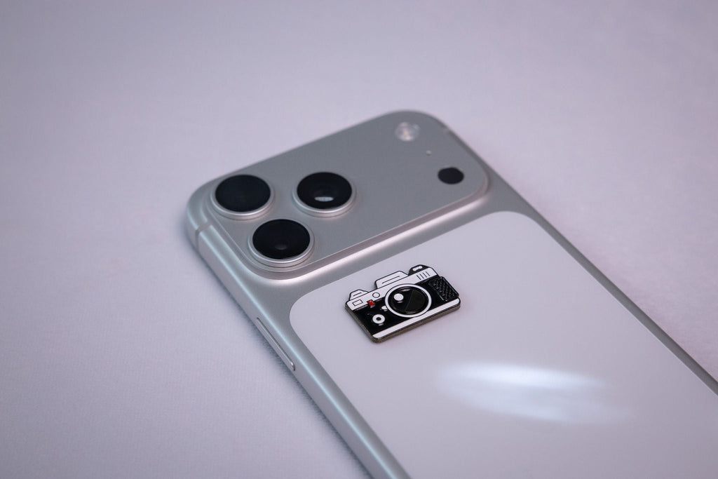 The retro camera metal sticker applied to a phone case near the camera bump.