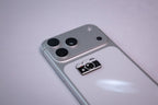 The retro camera metal sticker applied to a phone case near the camera bump.
