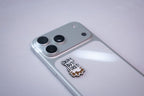 The Okay But First Kahwa metal sticker applied to a phone case near the camera bump.