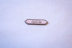 Alhamdulillah (الحمد لله) in black calligraphy on a soft pink scalloped-label sticker with a thin pink pinstripe border, flat lay on a light gray background